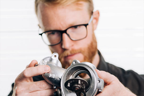 Ingenieur begutachtet mit einem prüfenden Blick ein Bauteil